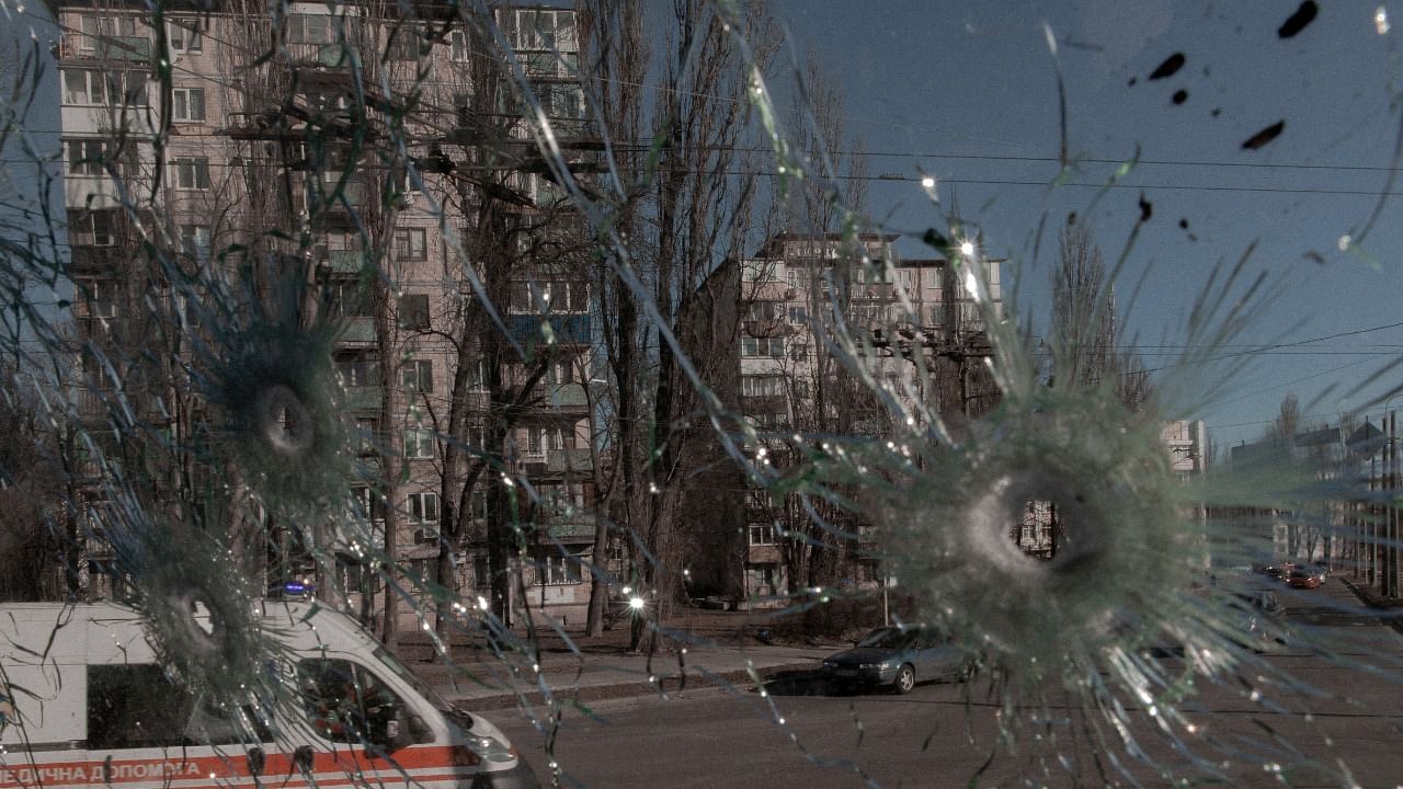 An ambulance is seen through the damaged window of a vehicle hit by bullets, as Russia's invasion of Ukraine continues, in Kyiv, Ukraine February 28, 2022. Credit: Jedrzej Nowicki/Agencja Wyborcza.pl via Reuters