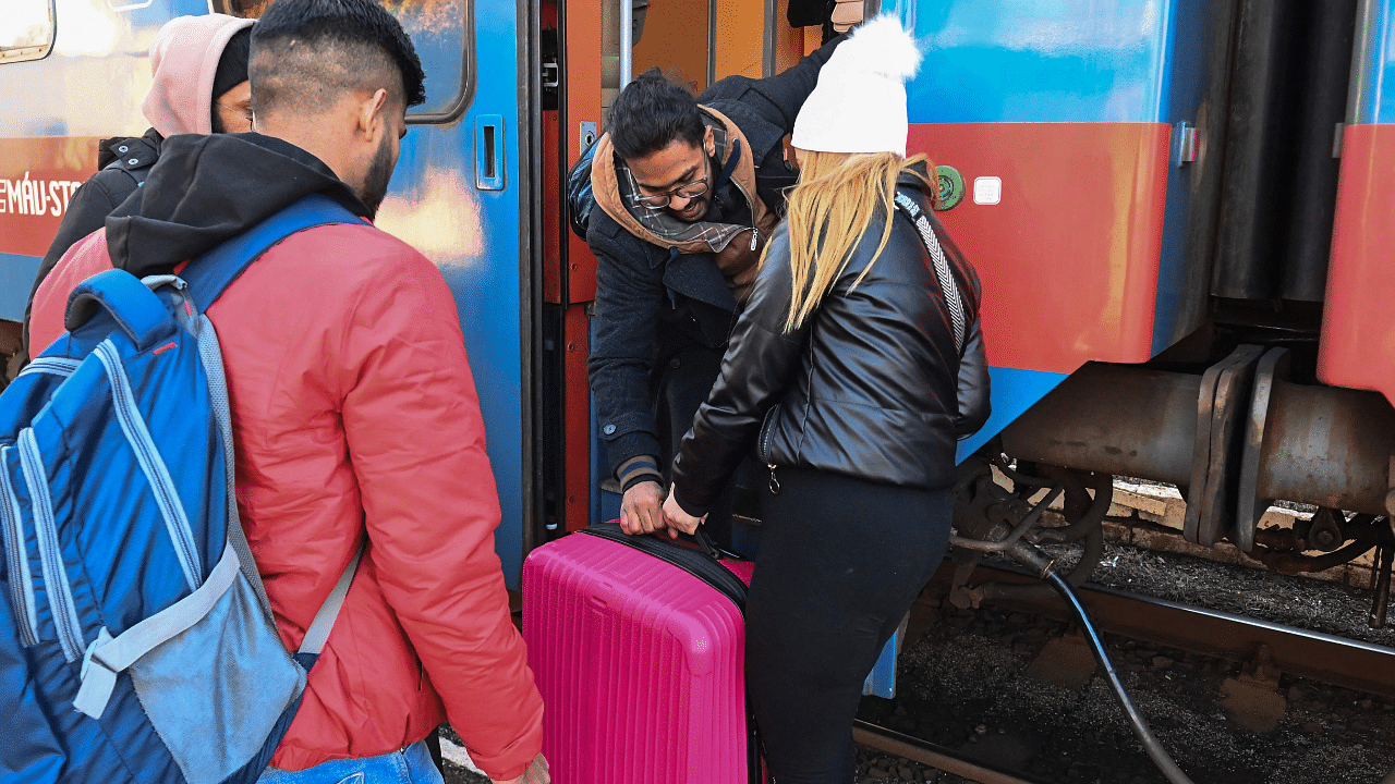 An Ukrainian refugee woman is helped by an Indian student of the Ukrainian capital Kyiv’s university at the railway station. Credit: AFP Photo