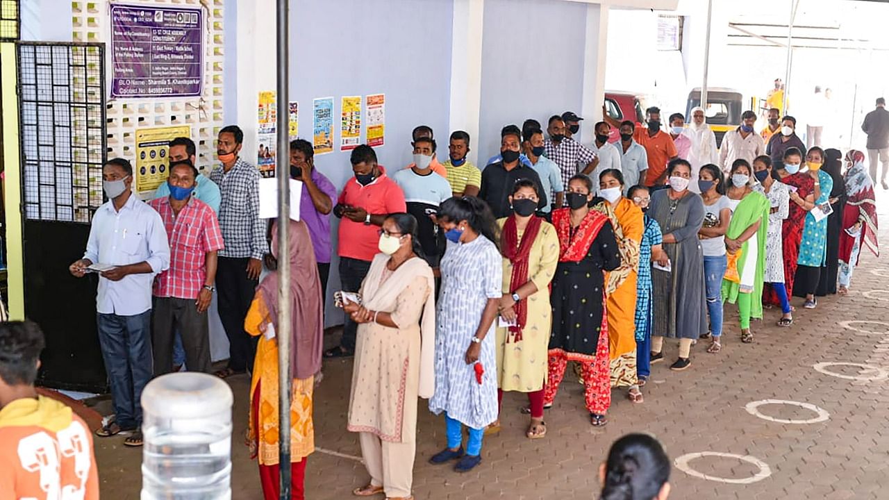 People stand in queues to cast their votes, during the Goa Assembly polls. Credit: PTI Photo