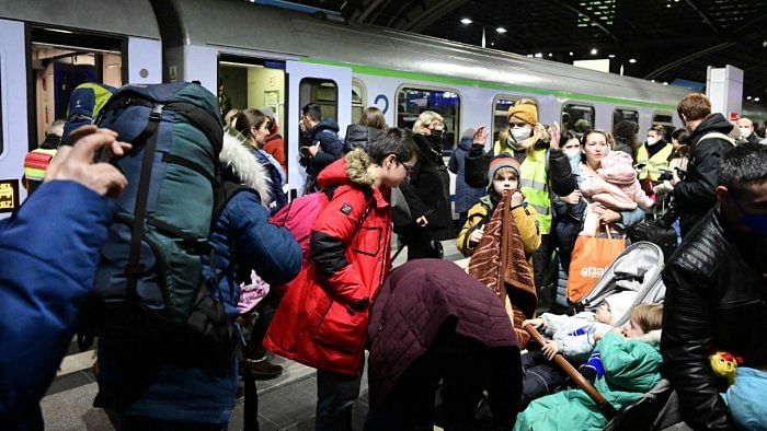 Refugees enter a train after fleeing from the Ukraine at the train station in Berlin, Germany. Credit: AFP Photo