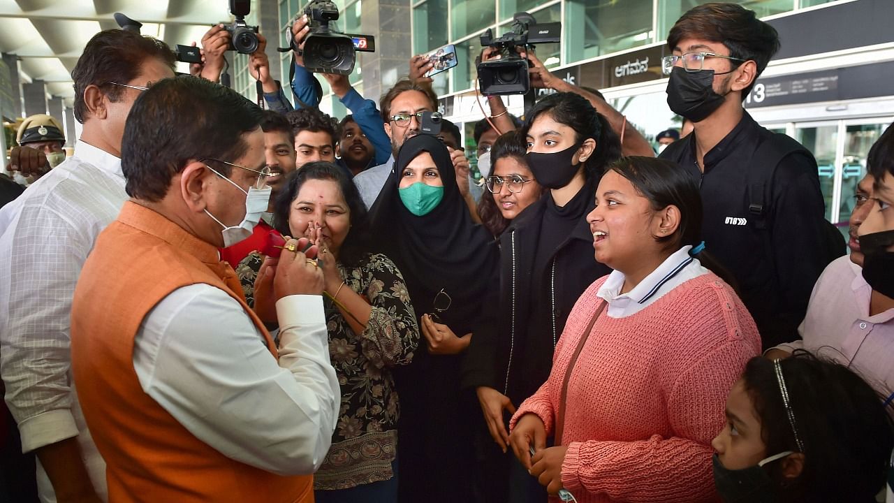 Union Parliamentry Affairs Minister Prahlad Joshi (L) welcomes Indian nationals, evacuated from crisis-hit Ukraine, upon their arrival at the airport in Bengaluru, Sunday. Credit: PTI Photo