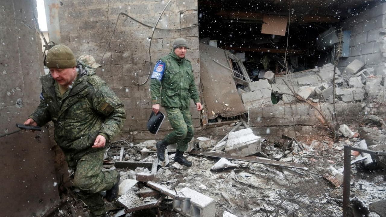 Officers of the Joint Centre for Control and Co-ordination (JCCC) inspect a damaged house following recent shelling in the separatist-controlled city of Donetsk, Ukraine March 3, 2022. Credit: Reuters Photo