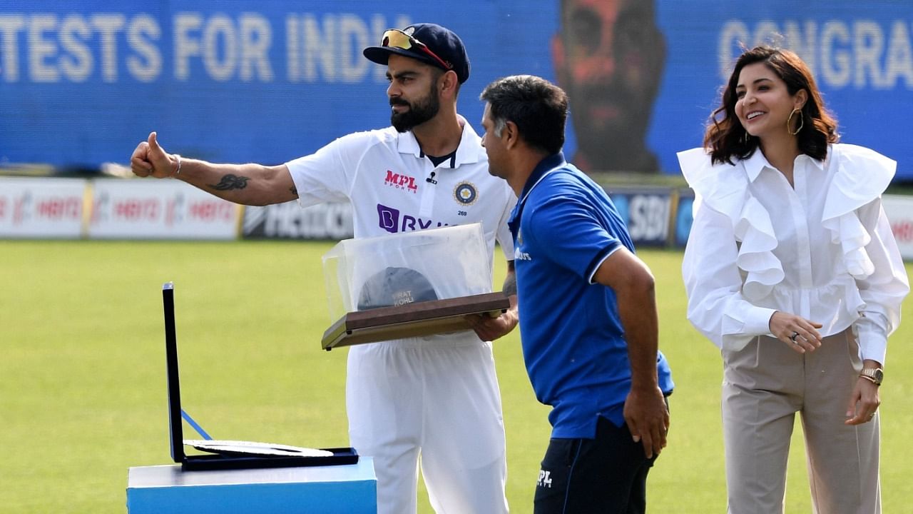 Rahul Dravid presents Kohli with a memento as Anushka Sharma looks on. Credit: AFP Photo