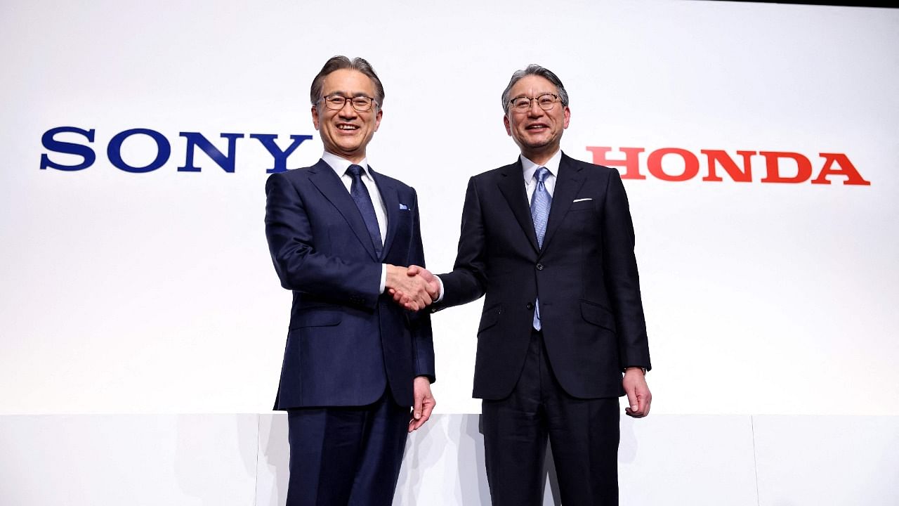 Sony president and CEO Kenichiro Yoshida (L) and Honda president Toshihiro Mibe pose as they shake hands at the end of a joint press conference in Tokyo. Credit: AFP Photo