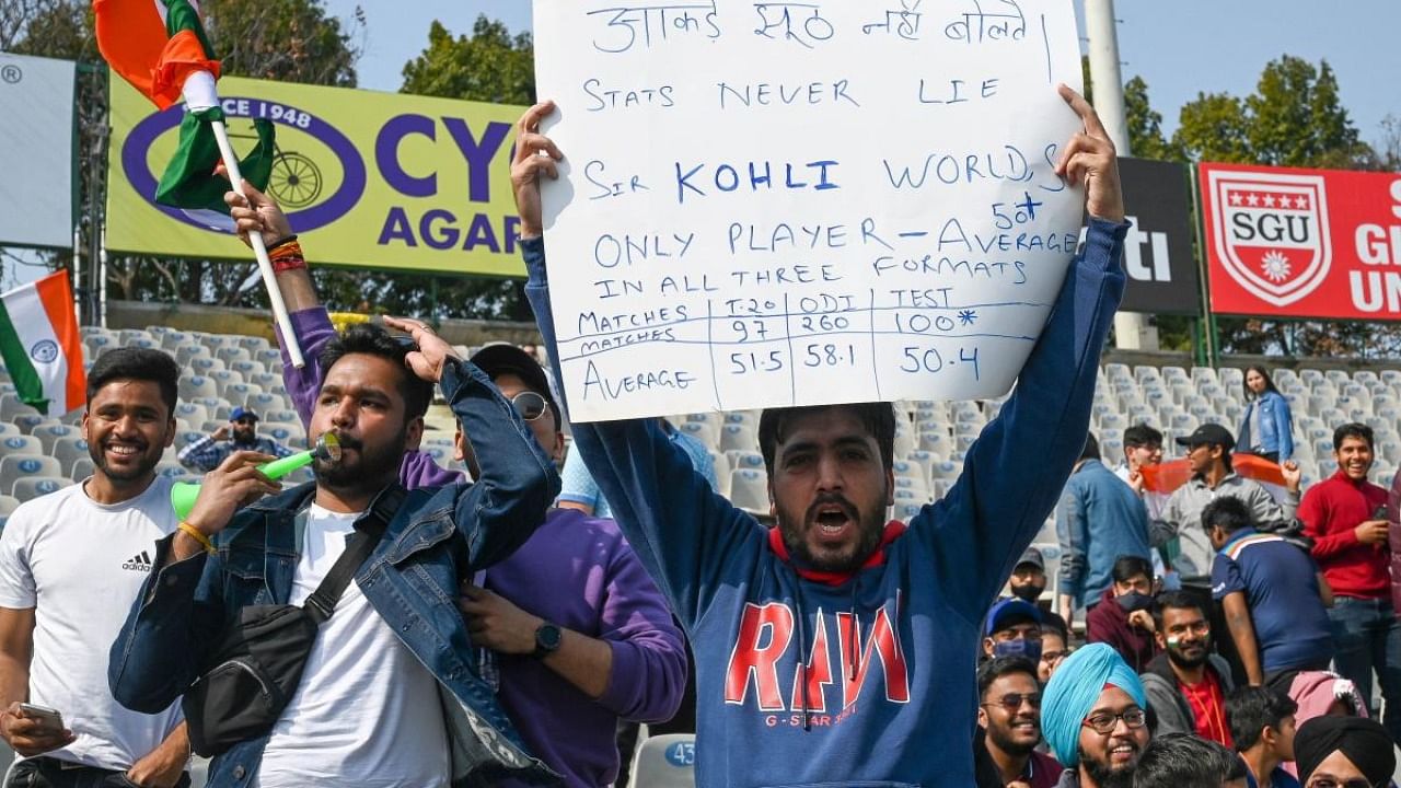 Fans of India's Virat Kohli cheer during the first day of the first Test cricket match between India and Sri Lanka at the Punjab Cricket Association Stadium in Mohali. Credit: AFP Photo