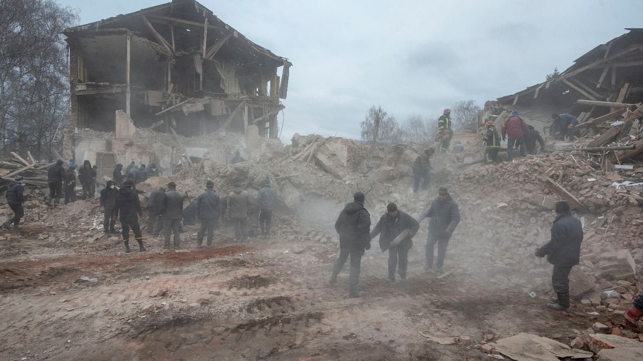 People remove debris at the site of a military base building that, according to the Ukrainian ground forces, was destroyed by an air strike, in the Sumy region. Credit: Reuters File Photo