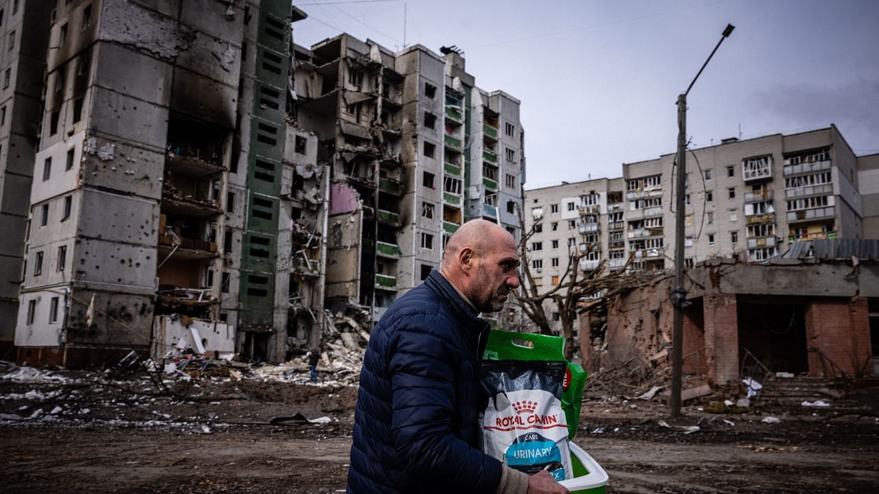 A man walks in front of a residential building damaged in shelling in the city of Chernihiv. Credit: AFP File Photo