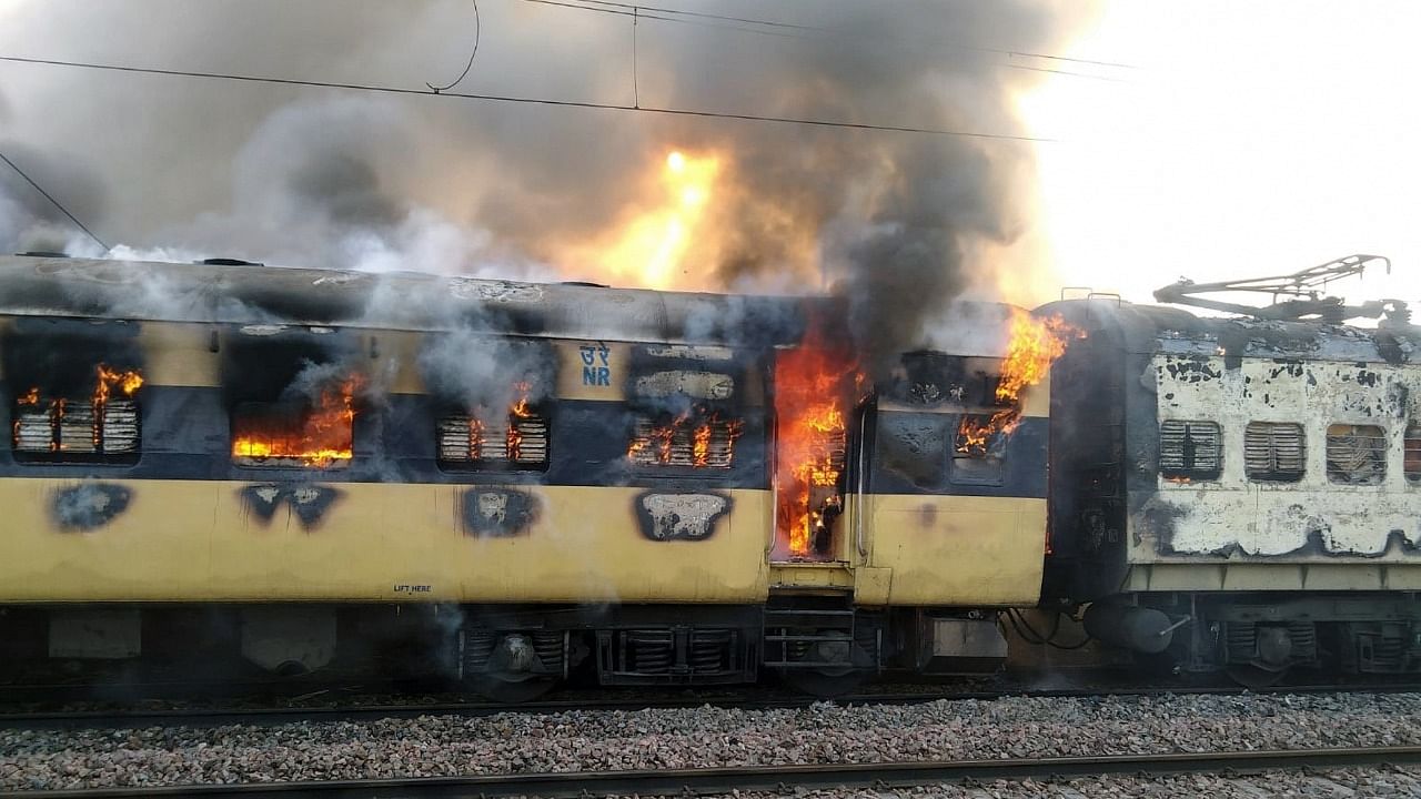 Flames rise after a fire broke out Saharanpur-Delhi passenger train at the Daurala Railway Station on Saturday. Credit: IANS Photo