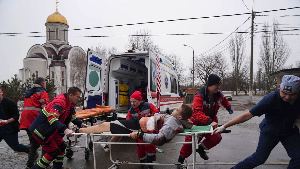 Ambulance paramedics move an injured man on a stretcher in Mariupol. Credit: AP Photo