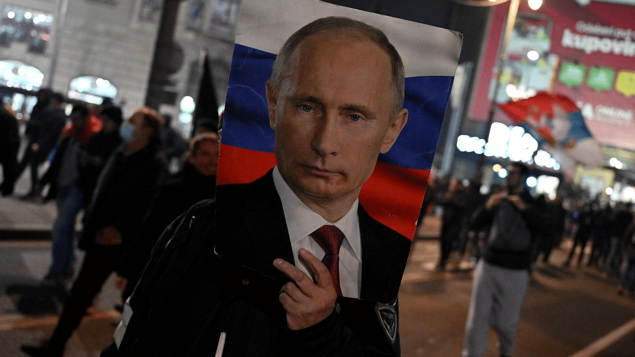 A man holds a portrait of Russian President Vladimir Putin during a rally origanised by Serbian right-wing organisations in support of Russian invasion in Ukraine. Credit: AFP Photo