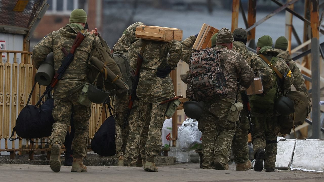 Ukrainian military members walk following the ongoing Russian invasion in Lviv, Ukraine. Credit: Reuters Photo
