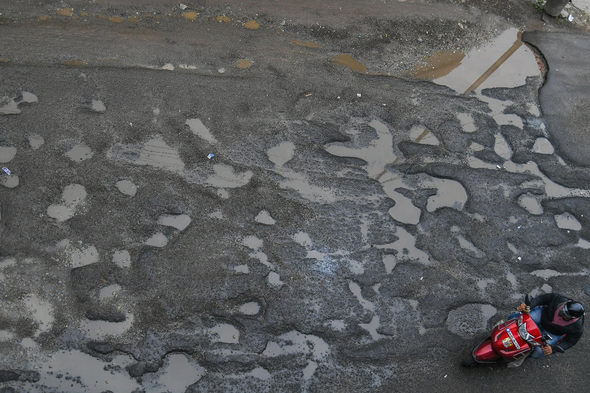 Motorists struggle to navigate a pothole-ridden stretch in the city. Credit: DH Photo