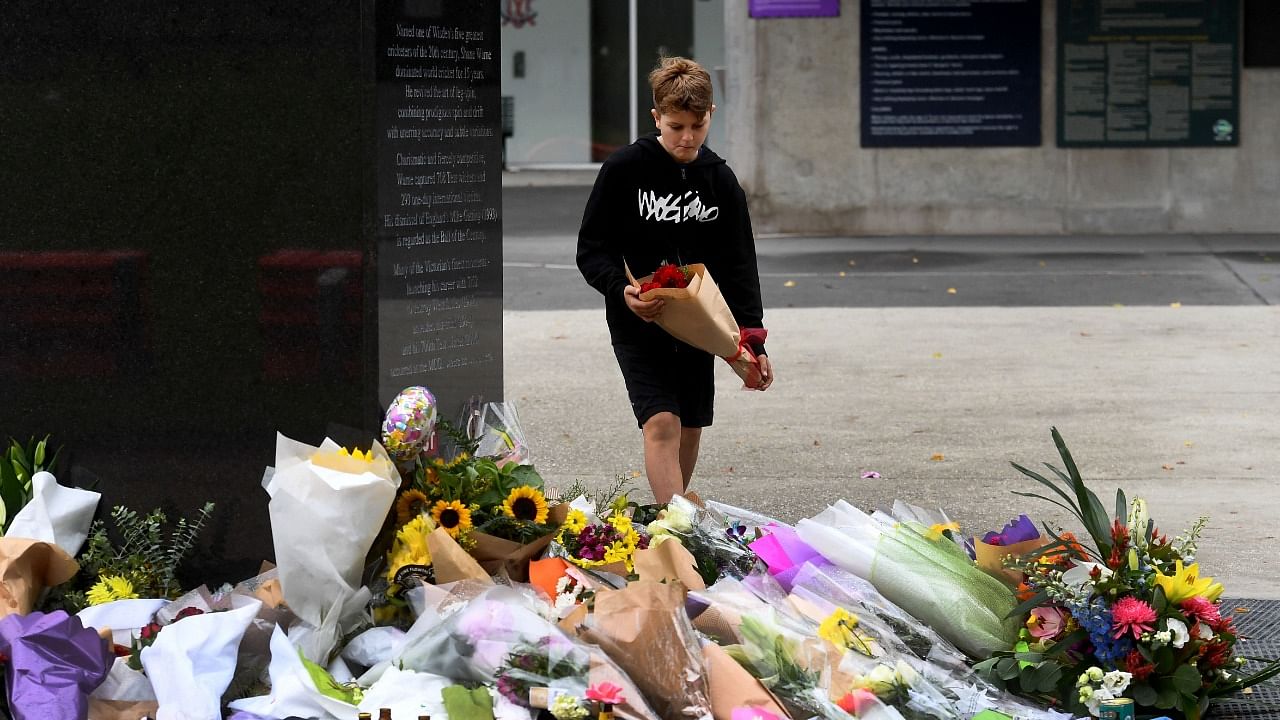 People pay their respects at a statue of former Australian cricket great Shane Warne outside the Melbourne Cricket Ground (MCG), in Melbourne on March 6, 2022. Credit: AFP Photo