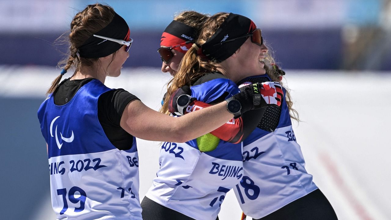 Team Canada celebrates after crossing the finishing line in the women’s long distance classical technique standing para cross-country skiing event. Credit: AFP Photo