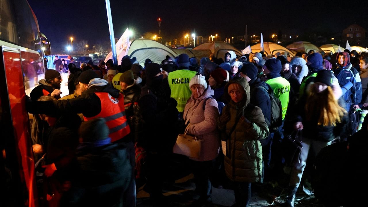 People fleeing the Russian invasion of Ukraine board a bus after crossing the border from Ukraine to Poland, at the border checkpoint in Medyka, Poland, March 7, 2022. Credit: Reuters Photo