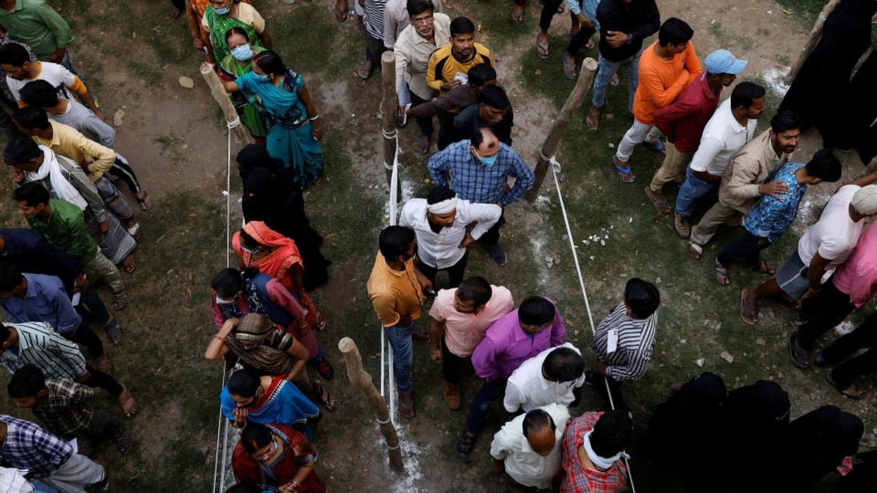 People stand in queue to cast their vote at a polling station during the last phase of state assembly election in Varanasi, Uttar Pradesh, March 7, 2022. Credit: Reuters Photo