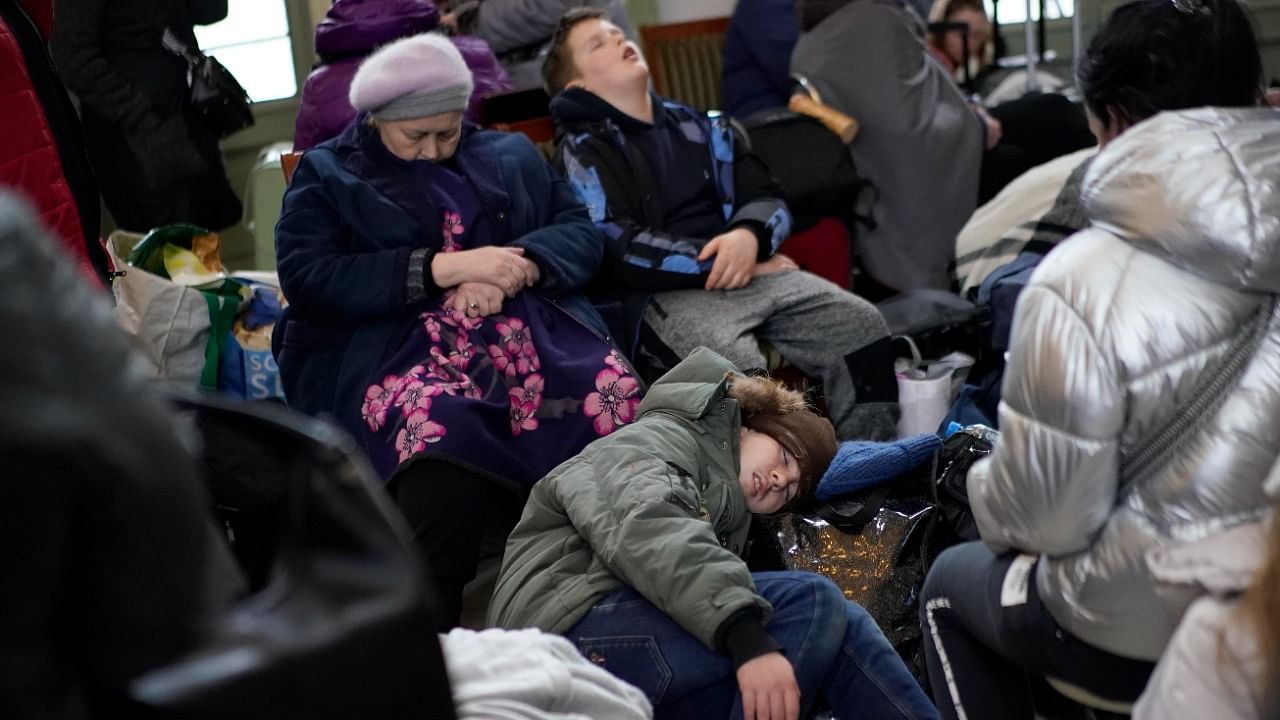 People who fled the war from neighboring Ukraine sleep at the Przemysl train station in Przemysl, Poland. Credit: AP Photo