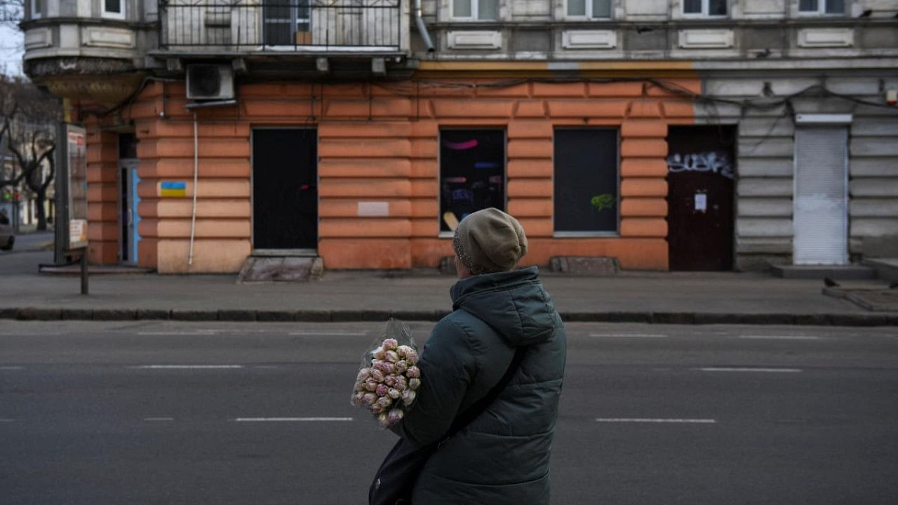 A woman stands on the street as she holds flowers, amid Russia's invasion of Ukraine, in Odessa. Credit: Reuters Photo