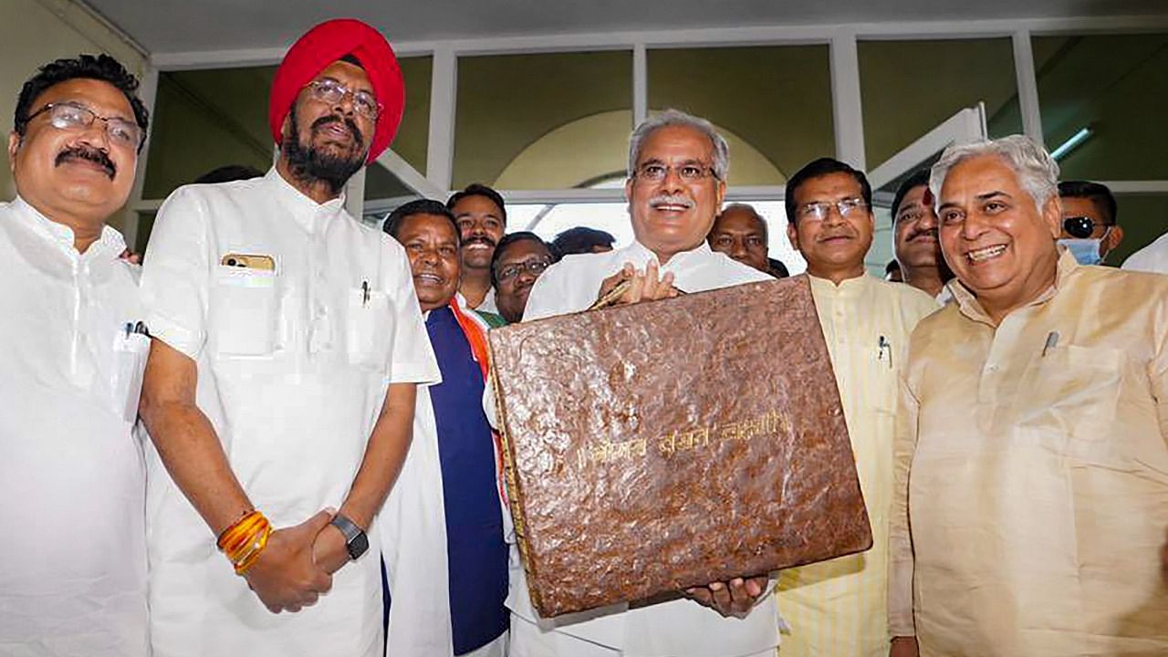 Bhupesh Baghel holds the Budget container, which was made of cow dung and flour. Credit: PTI Photo