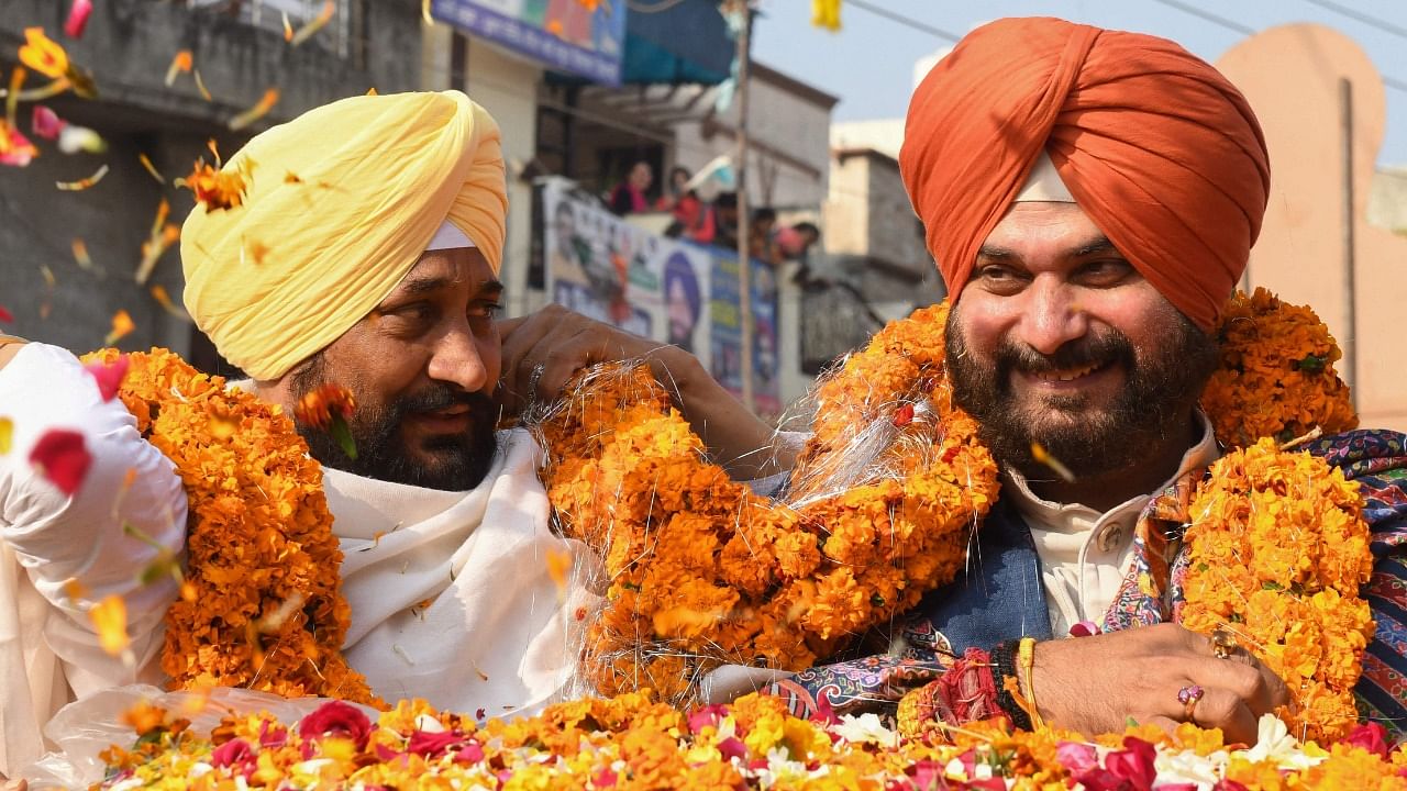 Charanjit Singh Channi (C/ yellow turban) with Punjab Congress party president and Congress party candidate Navjot Singh Sidhu (R). Credit: AFP File Photo
