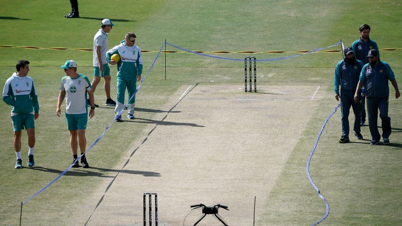 Pakistan's team members (R) and Australia's players inspect the pitch before the start of the fourth day play of the first Test cricket match between Pakistan and Australia at the Rawalpindi Cricket Stadium. Credit: AFP File Photo