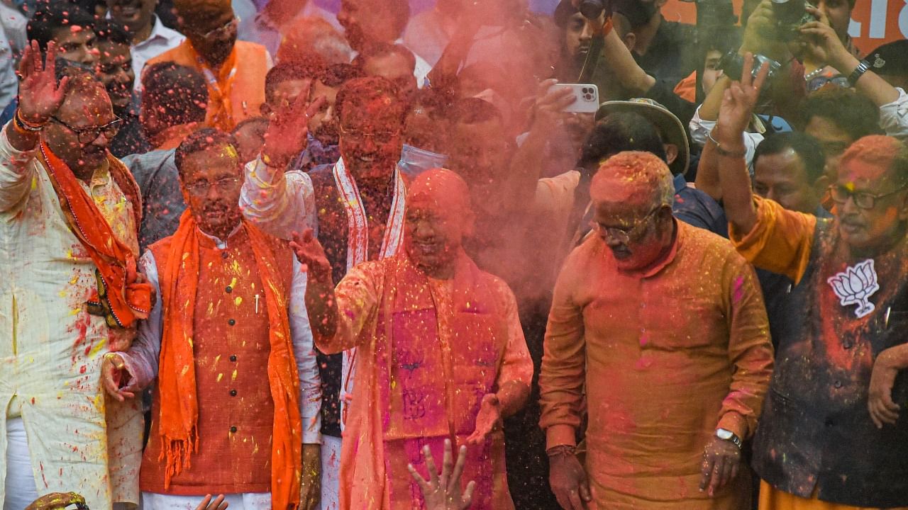 Uttar Pradesh Chief Minister Yogi Aditiyanath greets party workers during celebrations at the BJP office following their win in Assembly polls, in Lucknow. Credit: PTI Photo