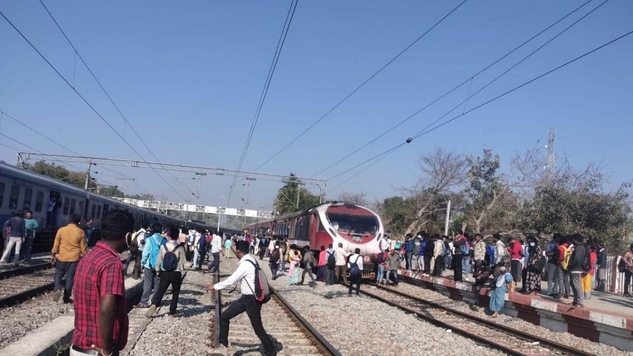 Passengers of two stationary trains cross tracks just before the arrival of Shatabdi Express at Tekal station in Malur taluk of Kolar district on Wednesday.. Credit: DH photo