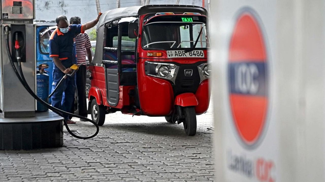 A worker fills petrol in an auto rickshaw at a Lanka IOC fuel station in Colombo. Credit: AFP Photo