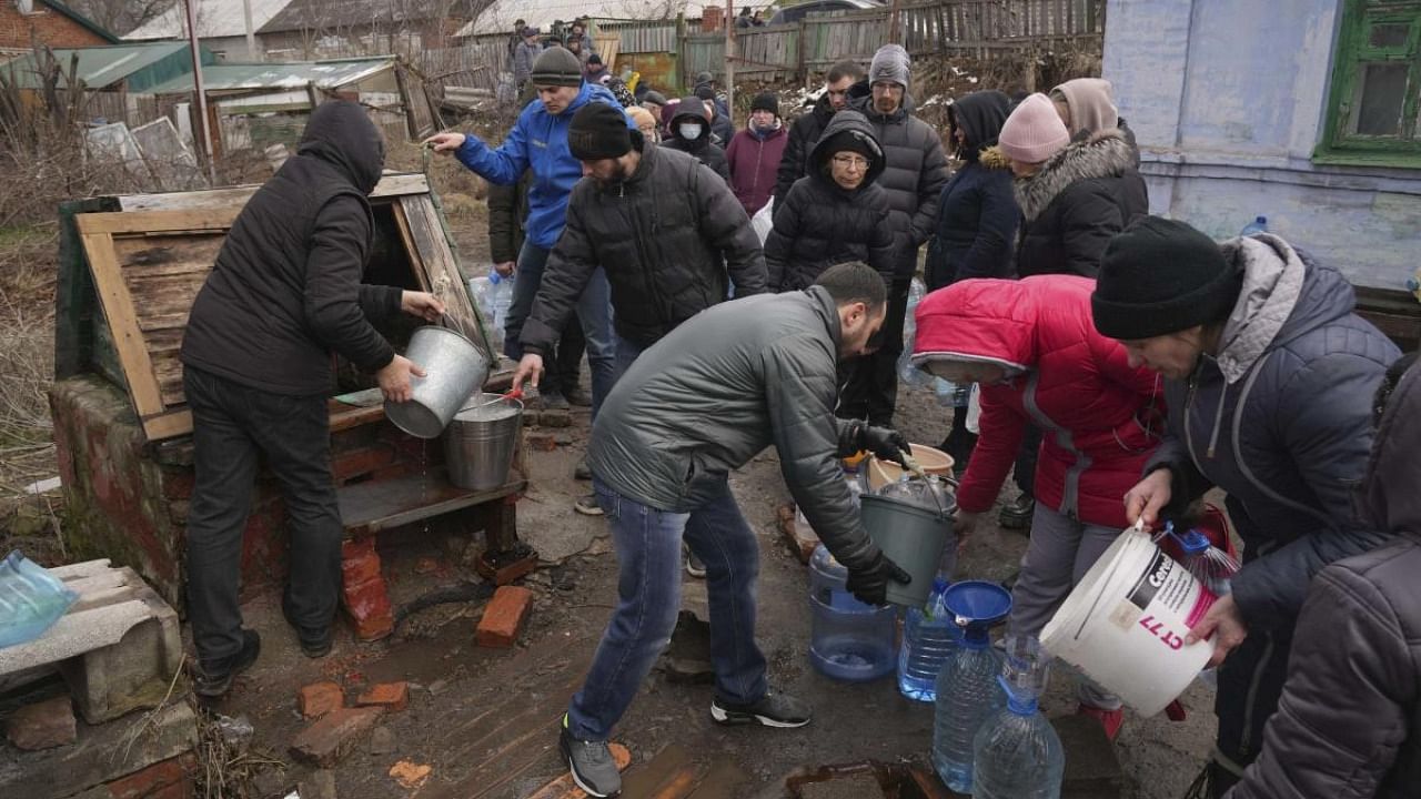 People line up to get water at the well in outskirts of Mariupol, Ukraine. Credit: AP/PTI Photo