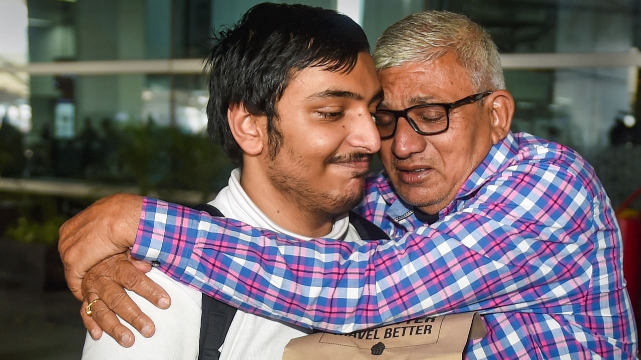 A man greets his son at the Delhi airport. Credit: PTI Photo