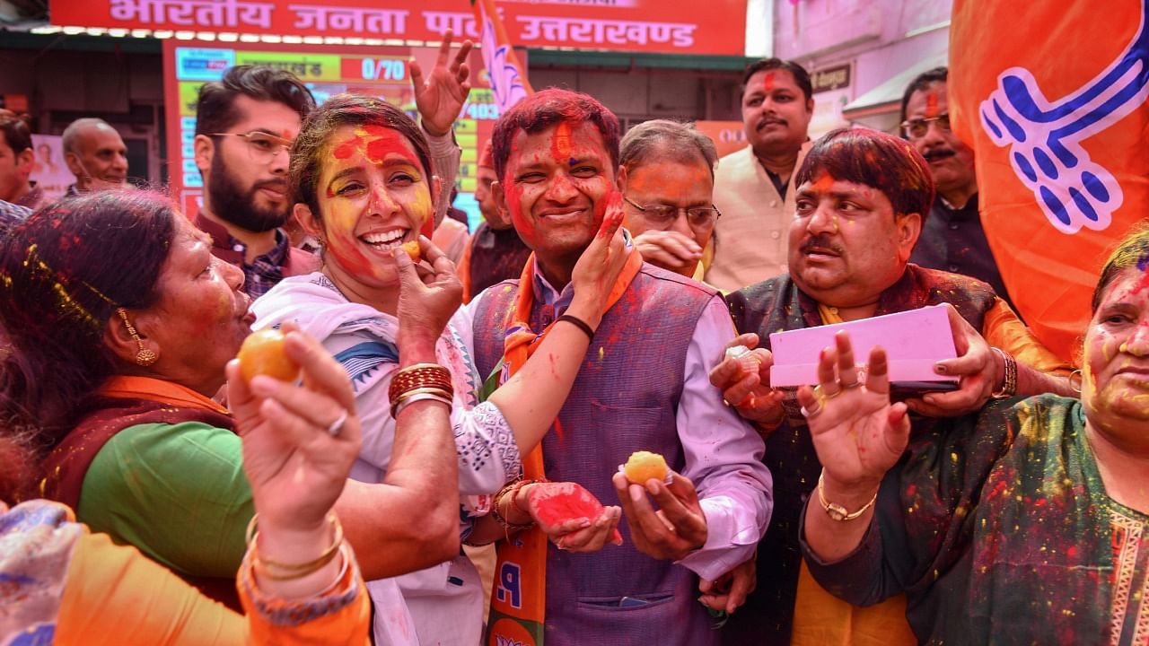 BJP supporters celebrate with colour after the party's lead in Uttarakhand Assembly polls, at BJP state office, in Dehradun. Credit: PTI Photo