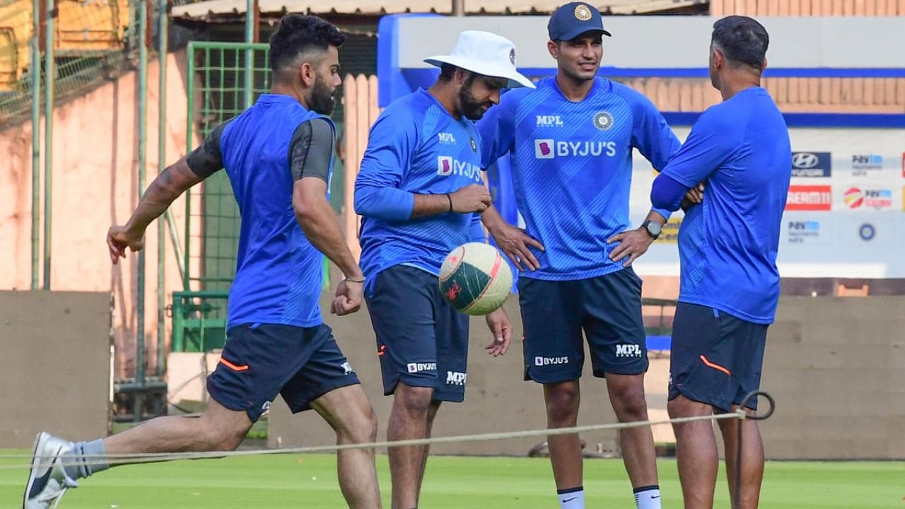 Indian coach Rahul Dravid (right) chats with Shubman Gill (second from right) as Indian skipper Rohit Sharma listens in. Former skipper Virat Kohli (left) is seen in the foreground at the M Chinnaswamy stadium in Bengaluru. Credit: DH photo/ S K Dinesh