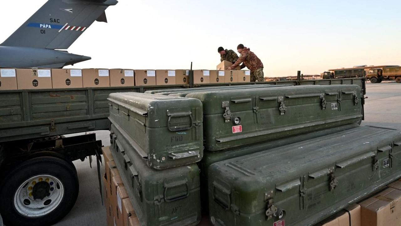 Servicemen of Ukrainian Military Forces load a flat bed truck with boxes as US made FIM-92 Stinger missiles (Front), a man-portable air-defence system (MANPADS), that operates as an infrared homing surface-to-air missile (SAM), are stacked after being shipped in to Boryspil Airport in Kyiv. Credit: AFP file photo