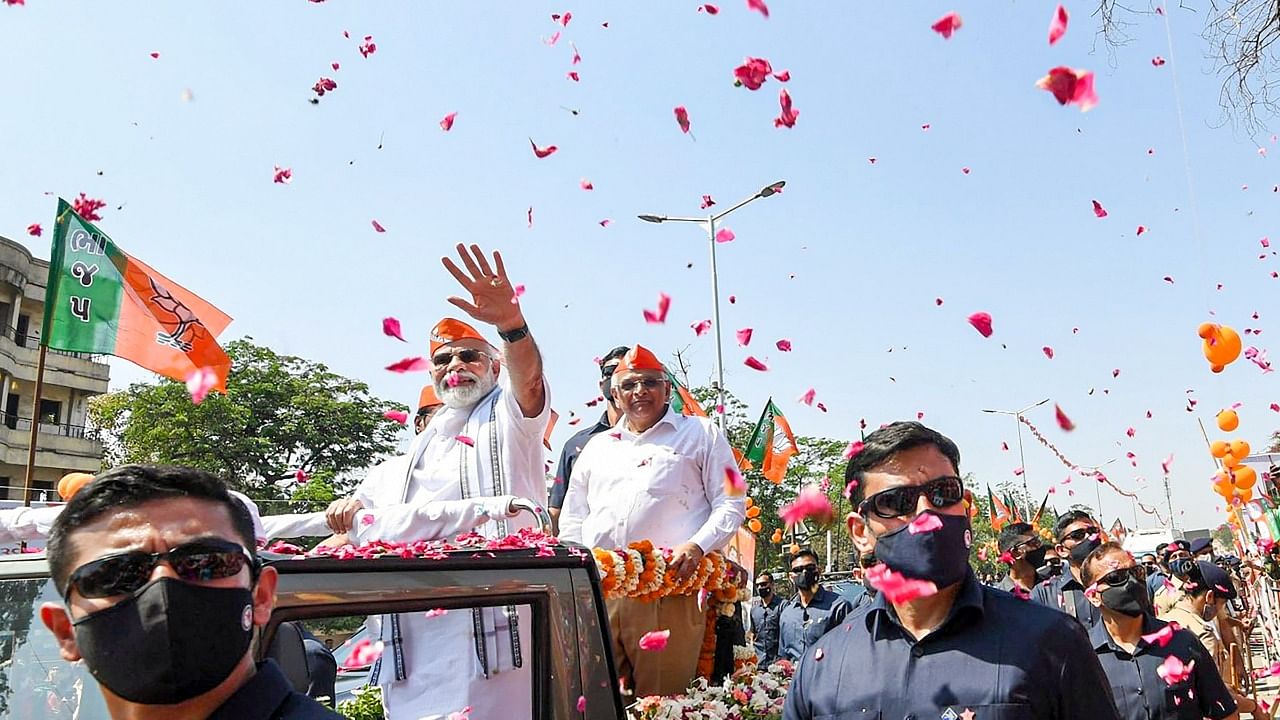 Prime Minister Narendra Modi waves at the supporters during a roadshow after BJP's victory in the recent Assembly polls, in Ahmedabad. Credit: PTI Photo