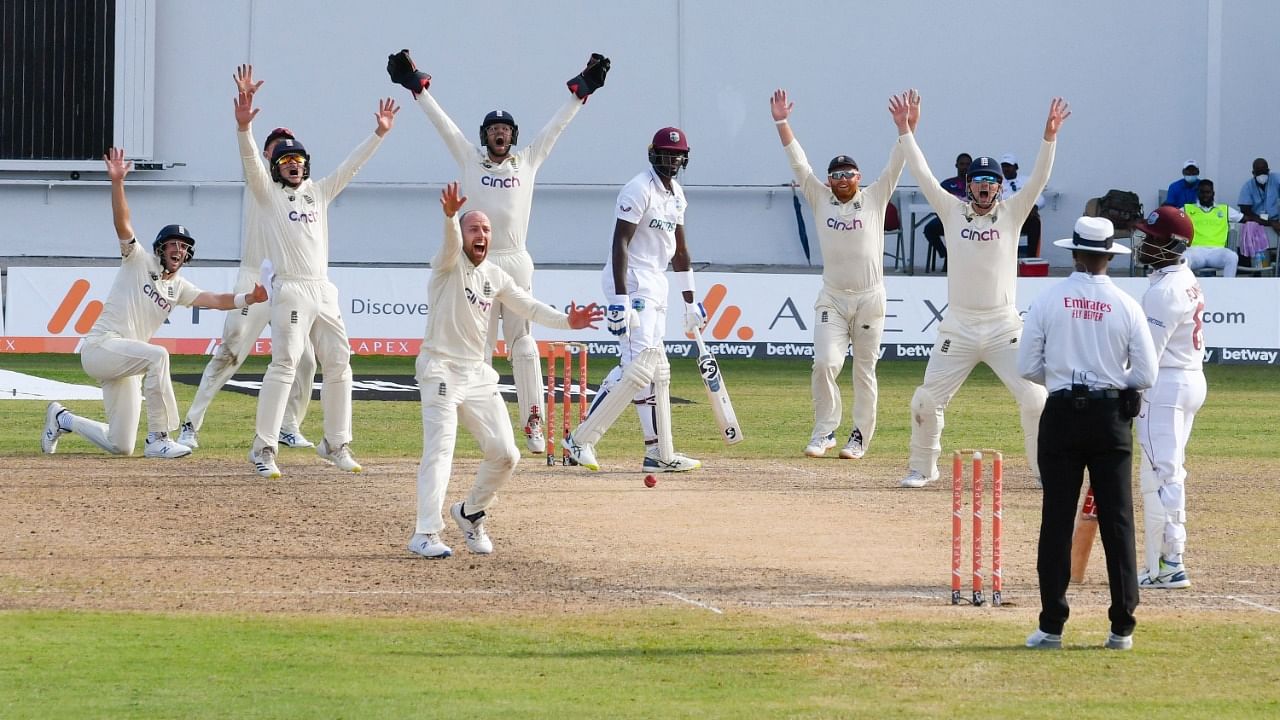 Jack Leach (3L) and teammates of England unsuccessfully appeal against Jason Holder (4L), of West Indies, during the fifth and final day of the 1st Test between England and West Indies at Vivian Richards Cricket Stadium in North Sound, Antigua and Barbuda. Credit: AFP Photo
