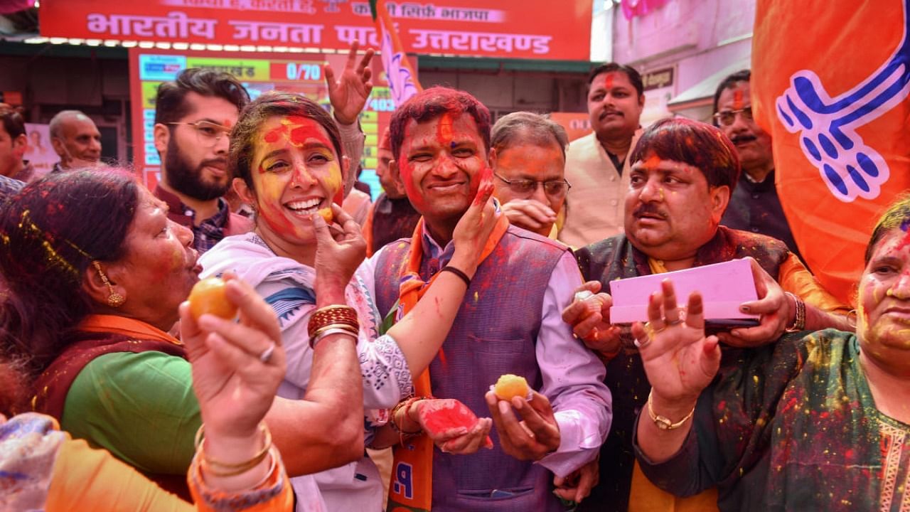 BJP supporters celebrate with colour after the party's lead in Uttarakhand Assembly polls, at BJP state office, in Dehradun. Credit: PTI Photo