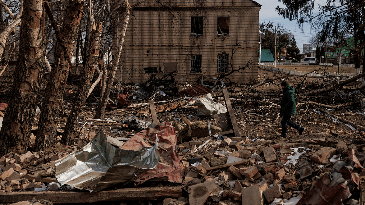 A man walks through the debris of a cultural center and an administration building that were destroyed during aerial bombing, in the village of Byshiv outside Kyiv. Credit: Reuters Photo