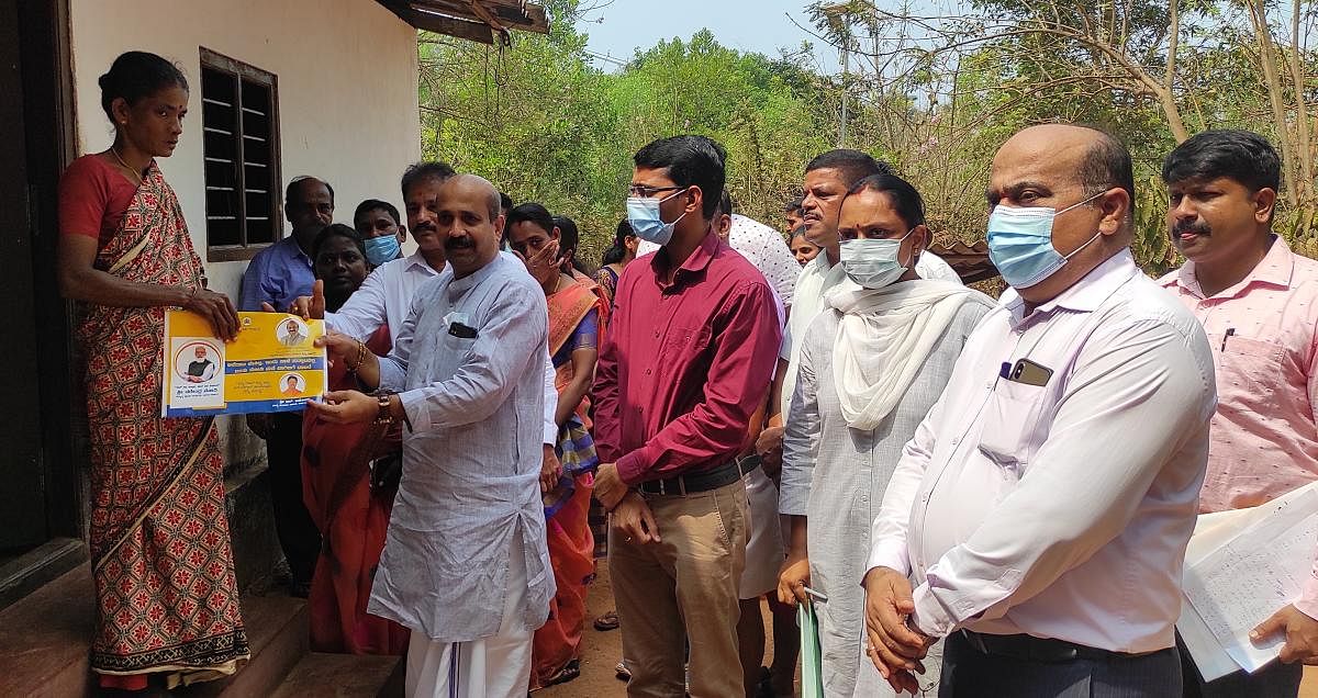 MLA Raghupathi Bhat delivers documents under ‘Kandaya Dakhale Mane Bagilige’ to a beneficiary in Lakshmipura in Tenkanidiyur Gram Panchayat on Saturday.