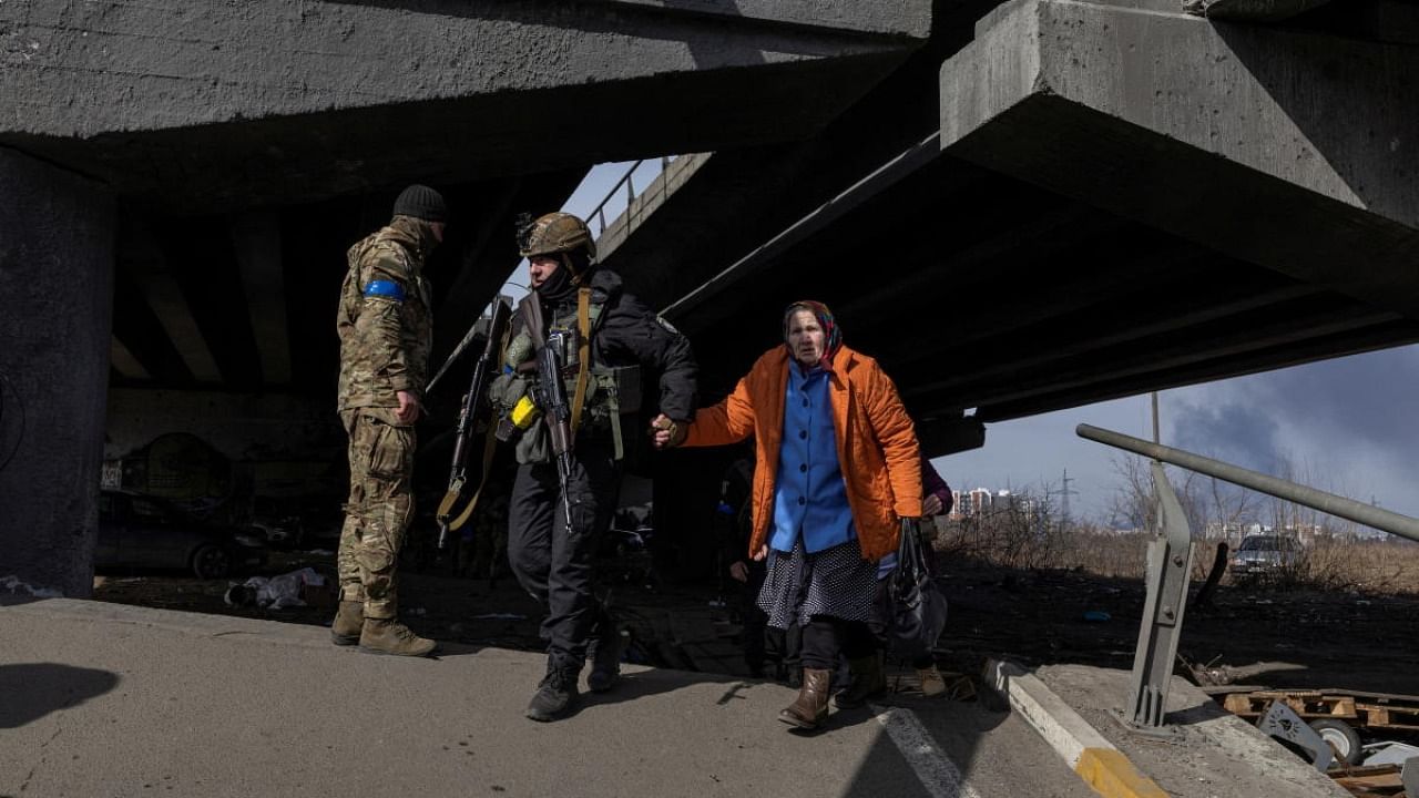 Ukrainian servicemen evacuate people as Russia's invasion of Ukraine continues, in the town of Irpin outside Kyiv. Credit: Reuters photo