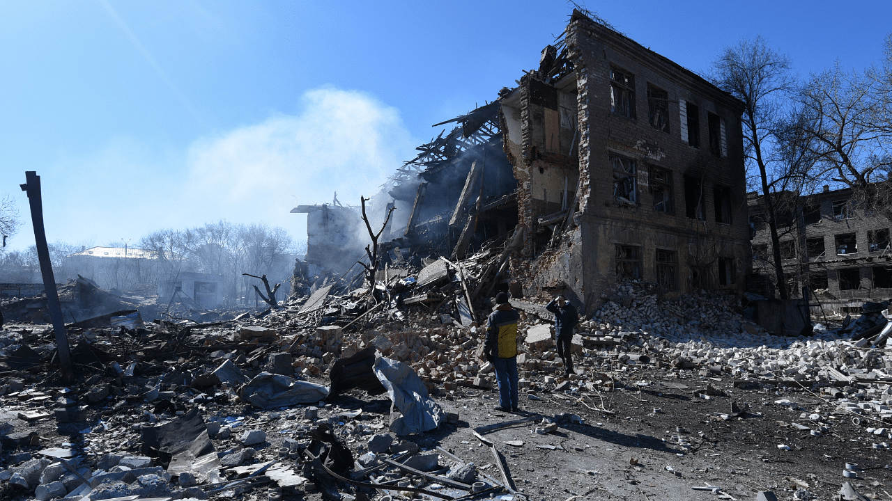 People stand in front of a destroyed shoe factory in the aftermath of a missile attack, amid Russia's invasion, in Dnipro. Credit: Reuters Photo