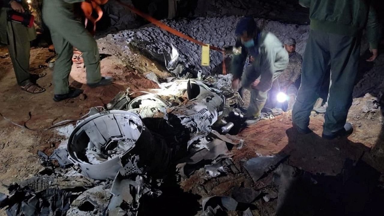People work around what Pakistani security sources say is the remains of a missile fired into Pakistan from India, near Mian Channu, Pakistan, March 9, 2022. Picture taken March 9, 2022. Credit: Pakistani security sources/Handout via Reuters