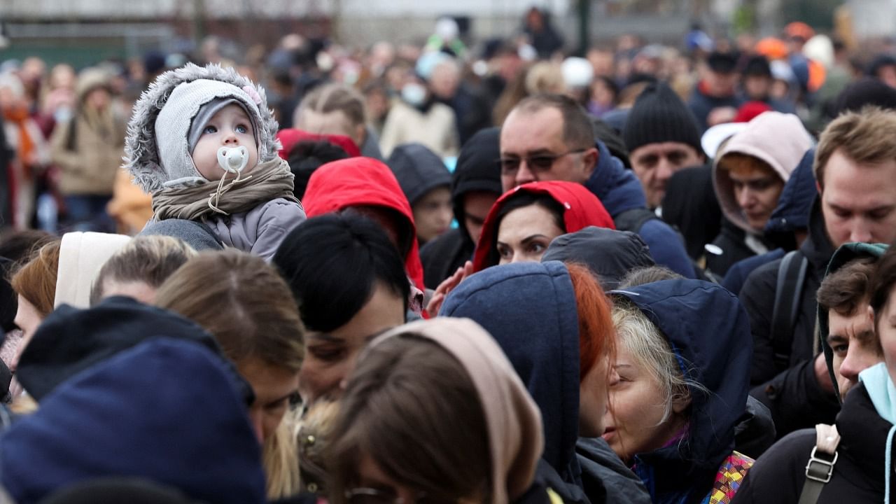 People wait outside an immigration office after fleeing from Ukraine to Belgium. Credit: Reuters Photo