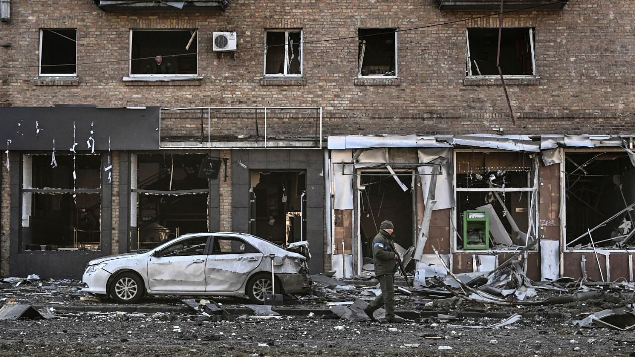 A Ukrainian serviceman walks in front of a destroyed apartment building after it was shelled in Kyiv. Credit: AFP Photo