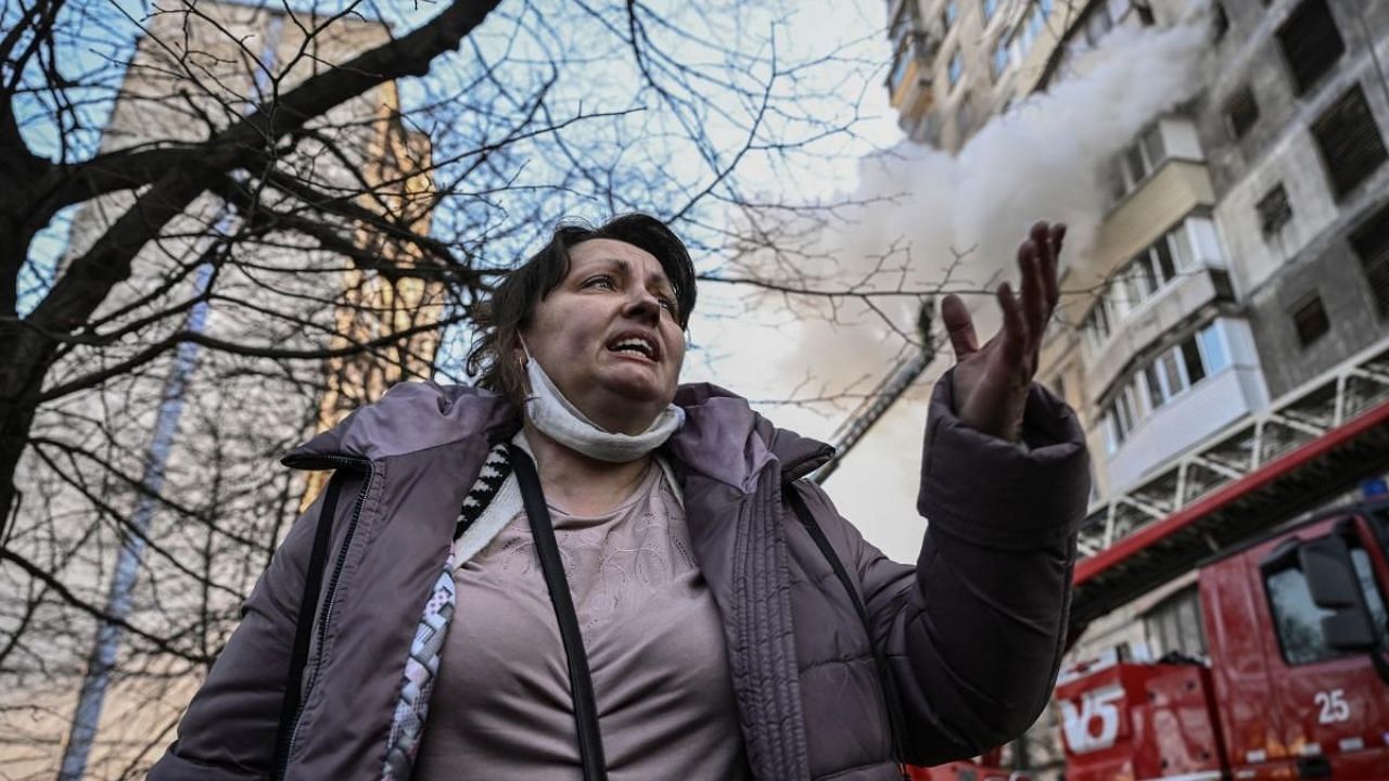 A woman reacts after being evacuated from a burning apartment building in Kyiv after strikes on residential areas killed at least two people. Credit: AFP Photo