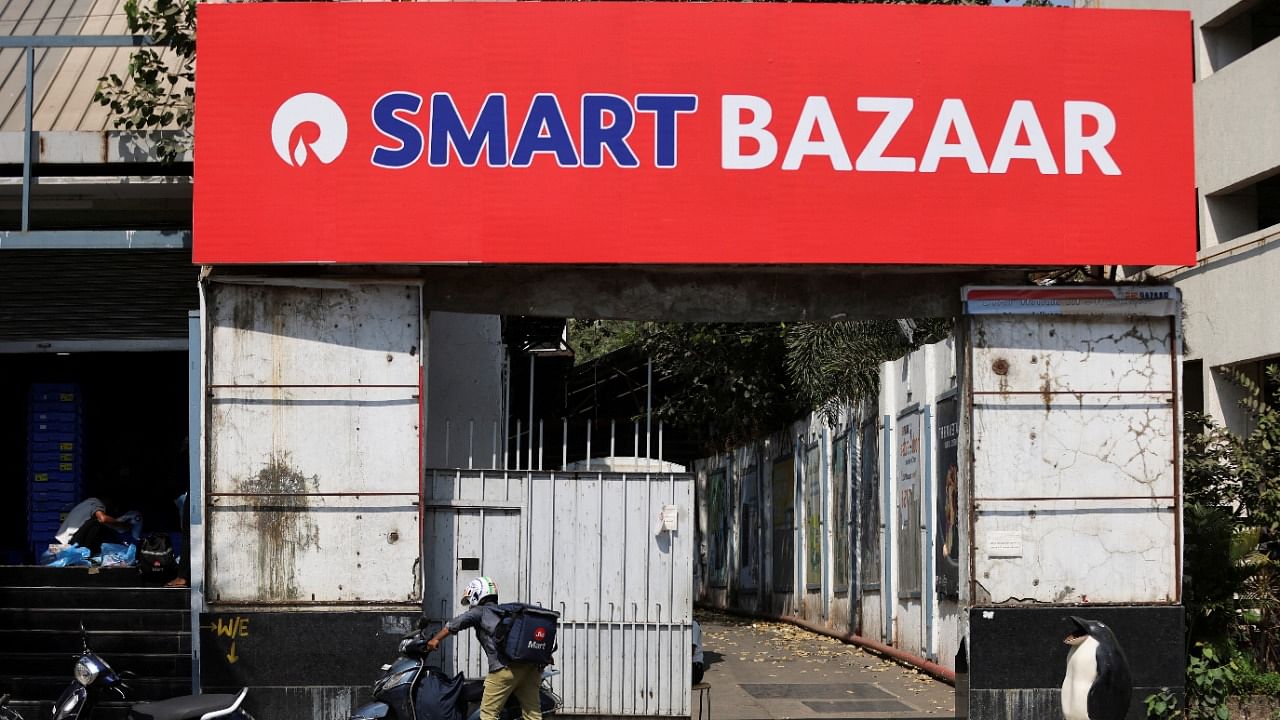 <div class="paragraphs"><p>A delivery boy parks his scooter outside a Reliance Smart Bazaar retail store. </p></div>