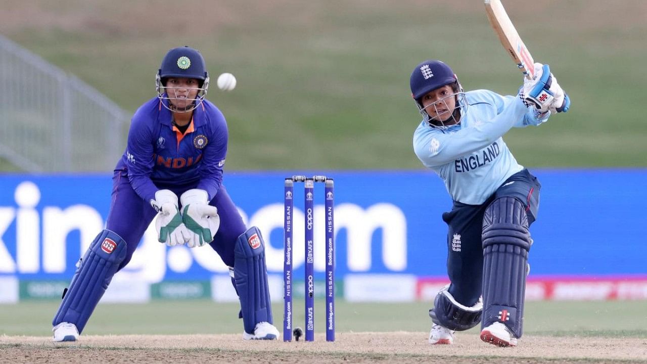 England’s Sophia Dunkley (R) plays a shot watched by India’s Richa Ghosh (L) during the 2022 Women's Cricket World cup match between England and India. Credit: PTI Photo