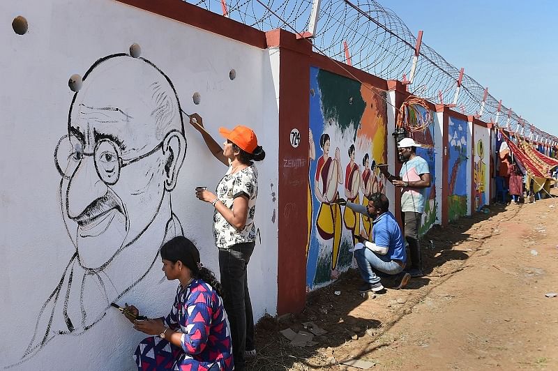 Students of various educational institutions and volunteers paint a picture of Mahatma Gandhi. (DH Photo)