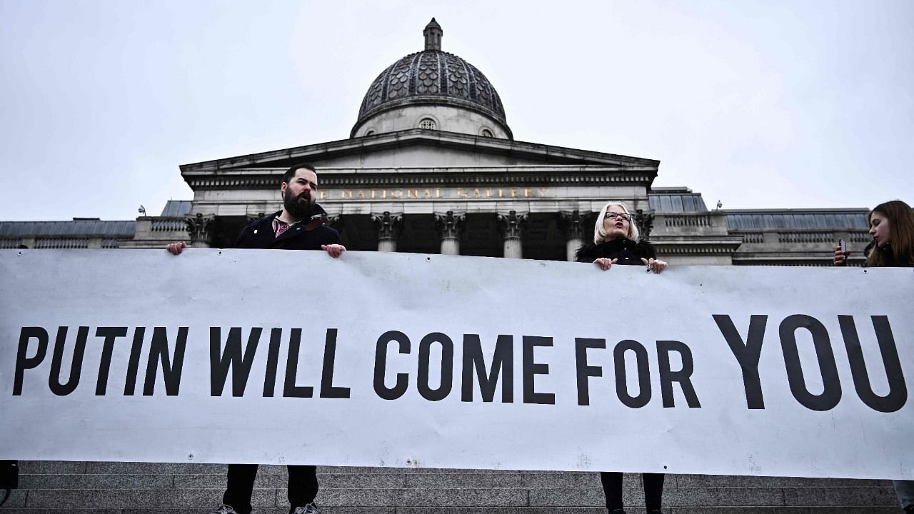 Demonstrators hold a banner as they gather in front of the National Gallery in Trafalgar square in central London. Credit: AFP Photo