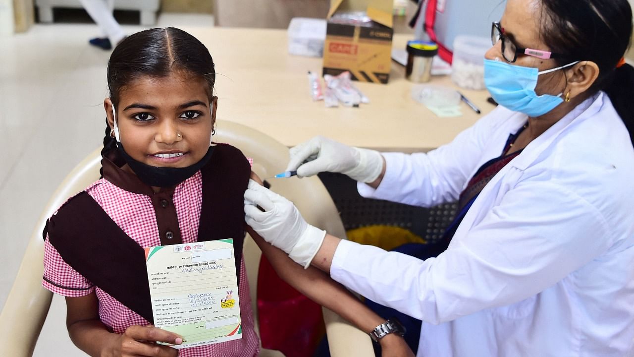 A health worker inoculates a youth with a dose of the Covid-19 Corbevax vaccine during a vaccination drive for people in the 12-14 age group at a vaccination centre in Allahabad. Credit: AFP Photo