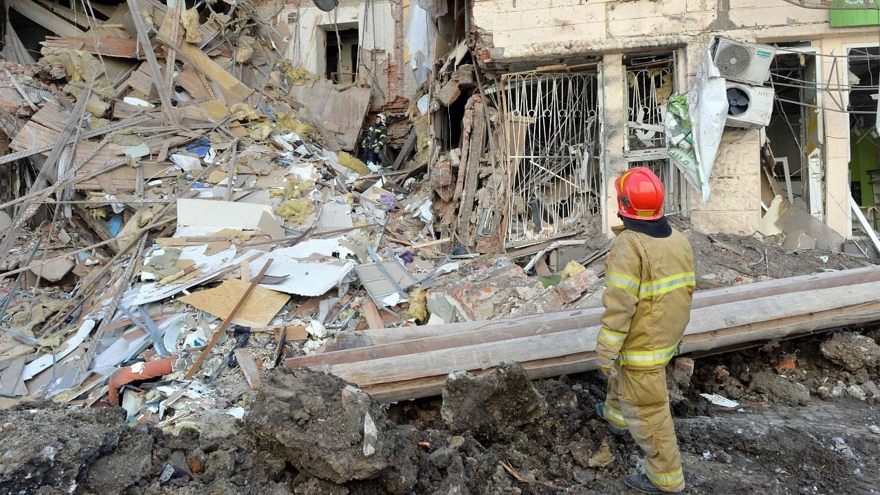 Rescuers remove debris from a building damaged by shelling in central Kharkiv. Credit: AFP Photo